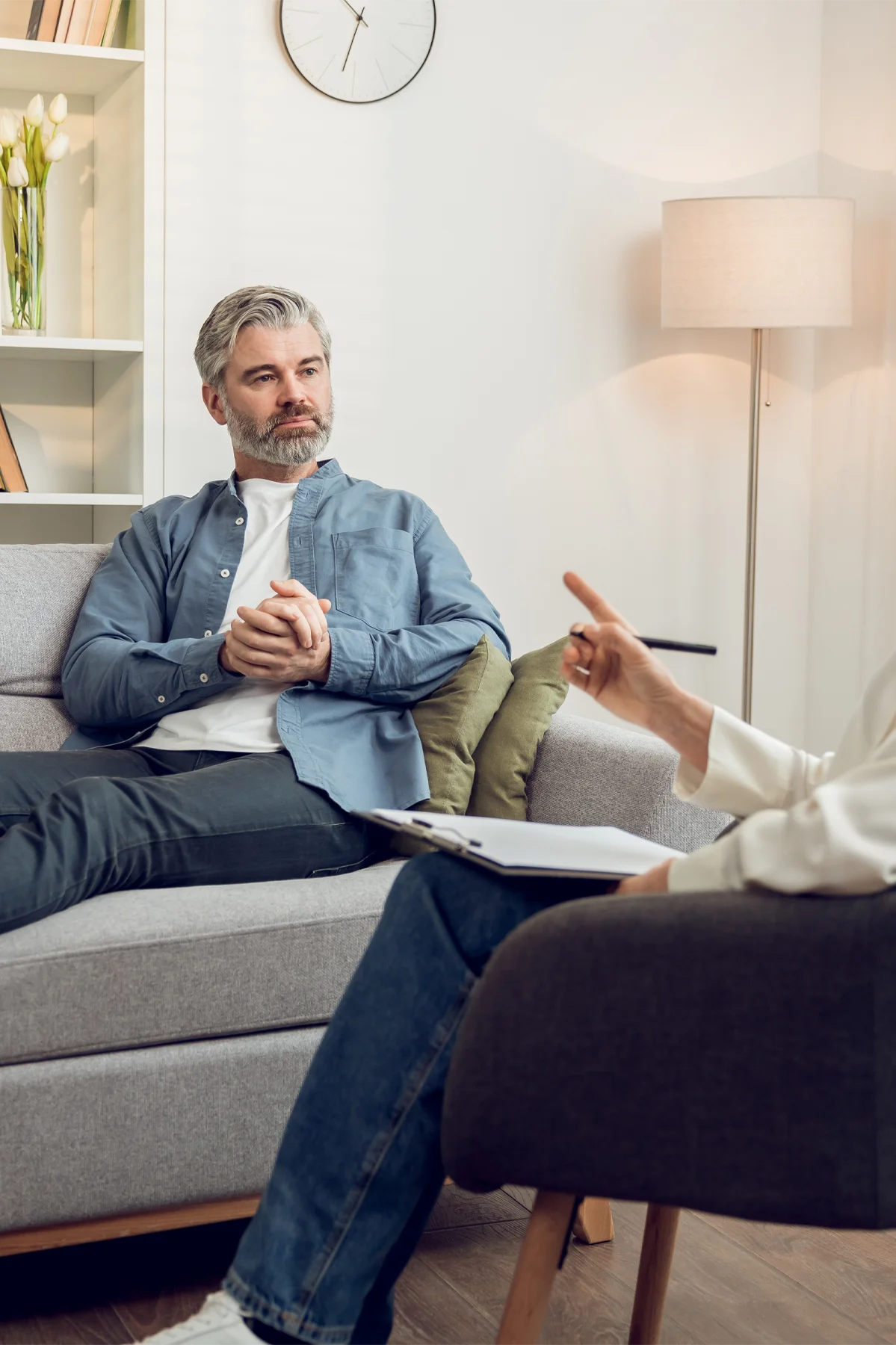 Man patient during therapy session with blonde woman psychologist in medical clinic