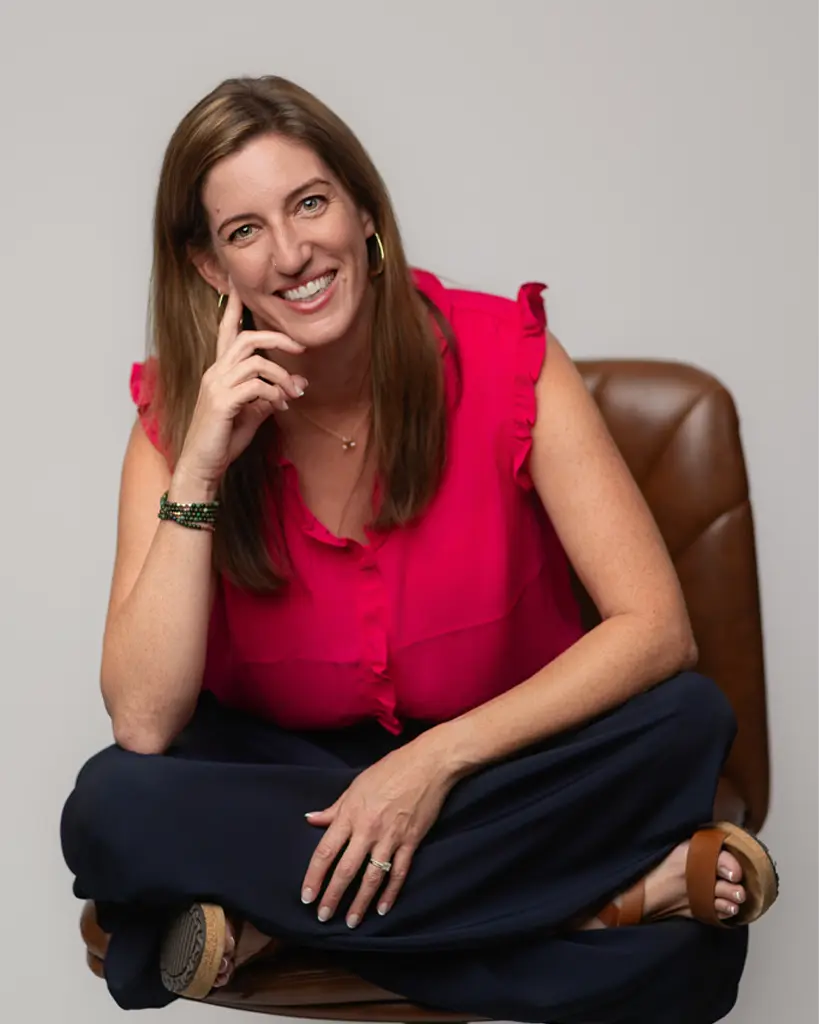 Kerstin McMillian, M.A., LCMHCA headshot sitting on a brown leather chair